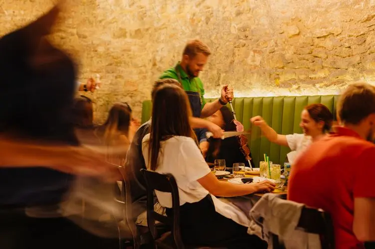 Passadores de carne serving grilled meat directly at the table.